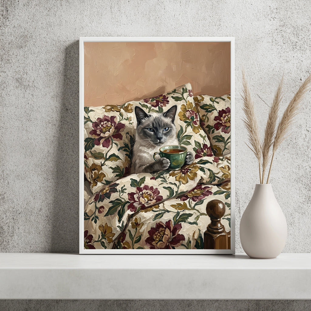 Siamkatze mit blauen Augen hält eine Teetasse auf geblümtem Sofa